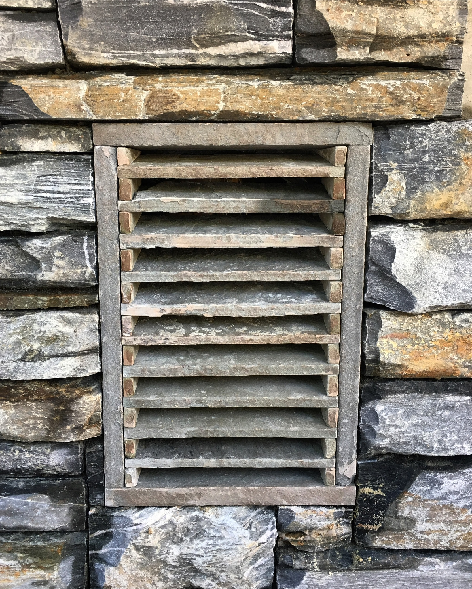 Custom stone vent grate with a slate surround