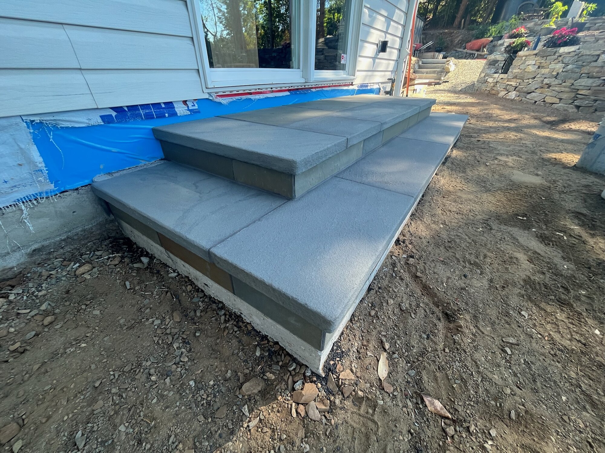 Wide three-tier grey granite platform entry steps, new construction