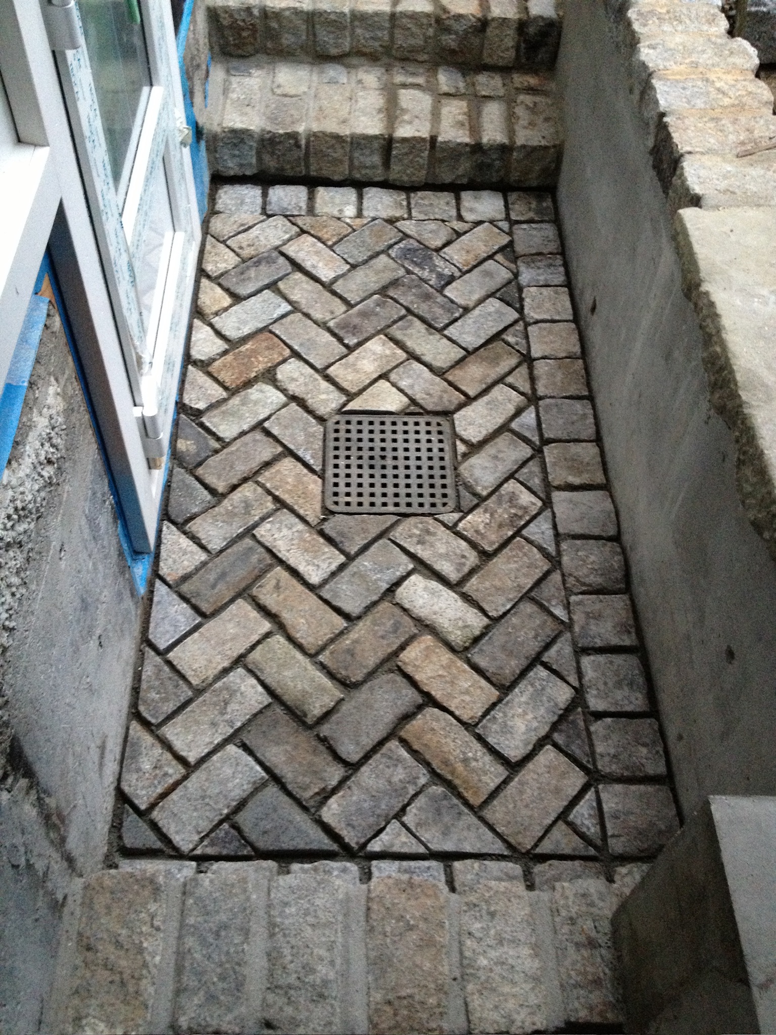 Herringbone brick walkway leading to a stairwell